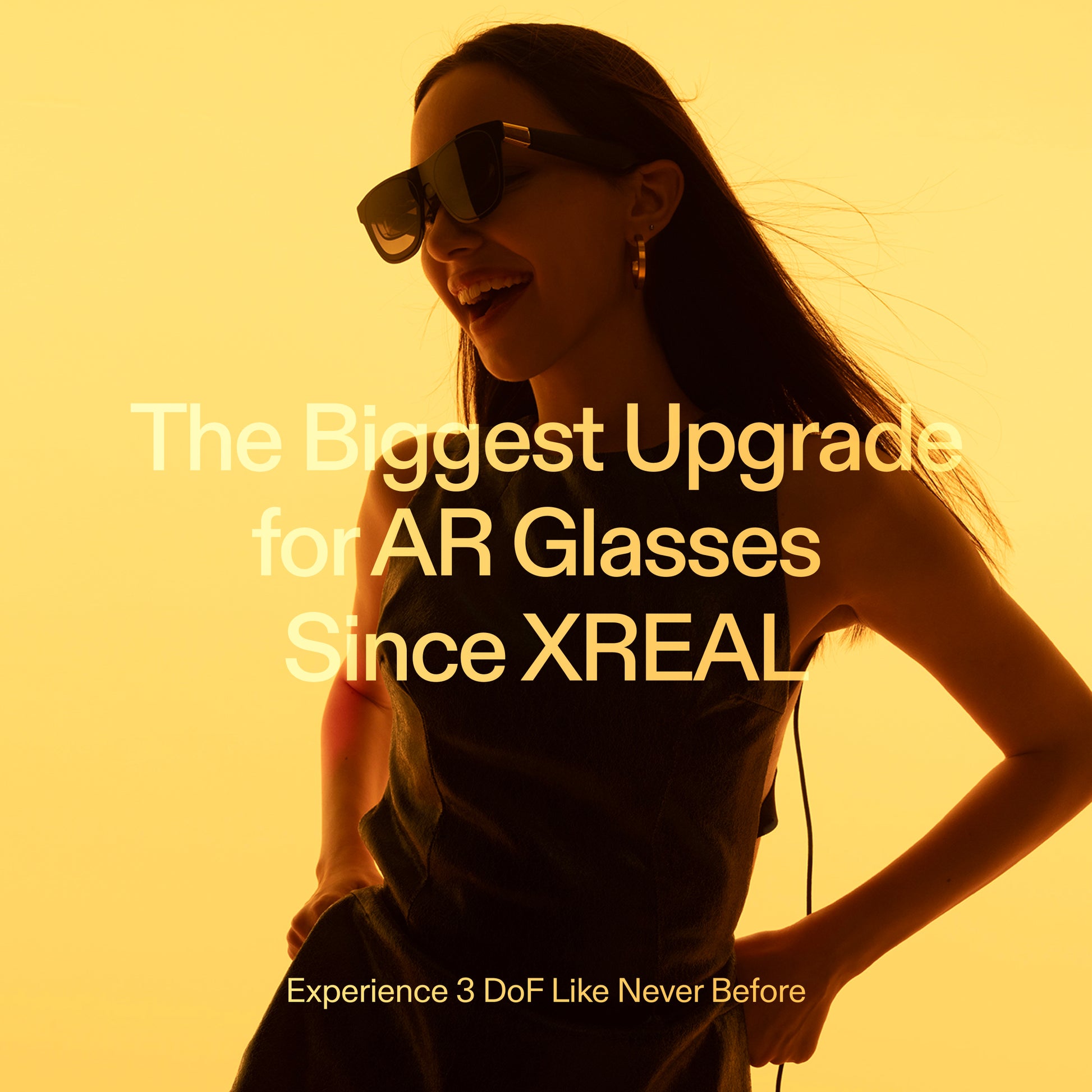 Smiling woman wearing XREAL AR glasses against a vibrant yellow background, showcasing the next-generation 3DoF upgrade for immersive augmented reality experiences